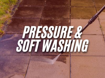 Image with the words "Pressure & Soft Washing" overlaying an image of a person pressure washing a stone walkway.